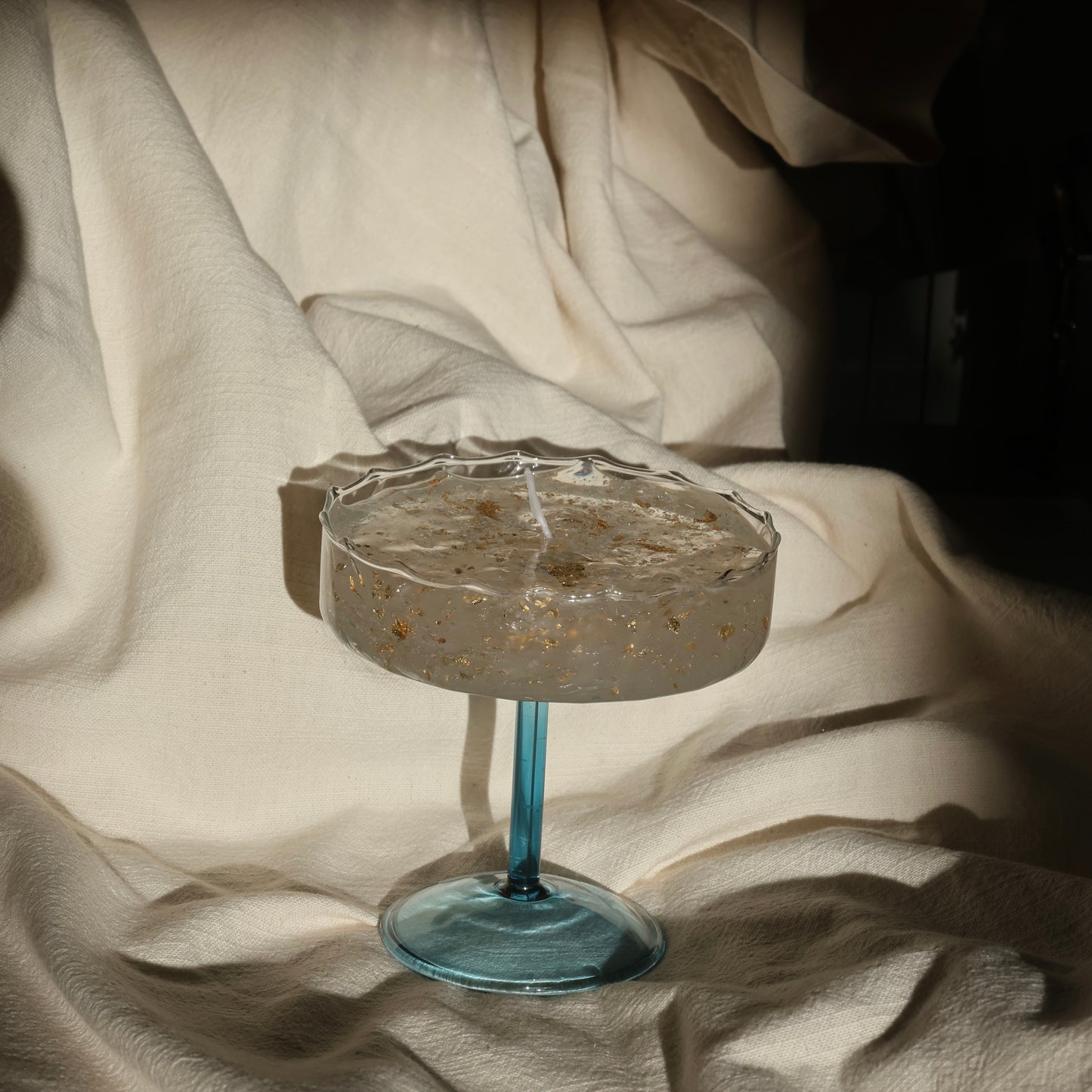 Clear gel candle with gold accents in a blue stemmed glass by Lily Glow Home Decor