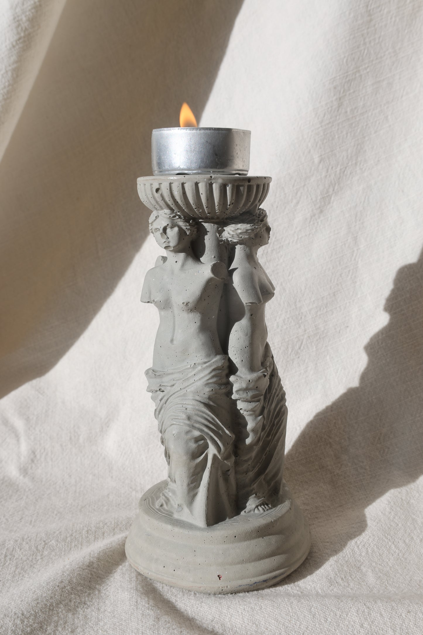 Concrete candle holder with three Venus by Lily Glow Home Decor figures and a tealight candle