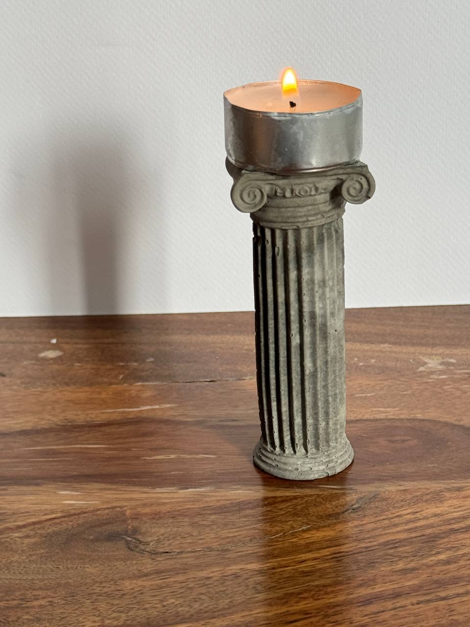 Concrete Ionic column candle holder with a lit tealight on top by Lily Glow Home Decor