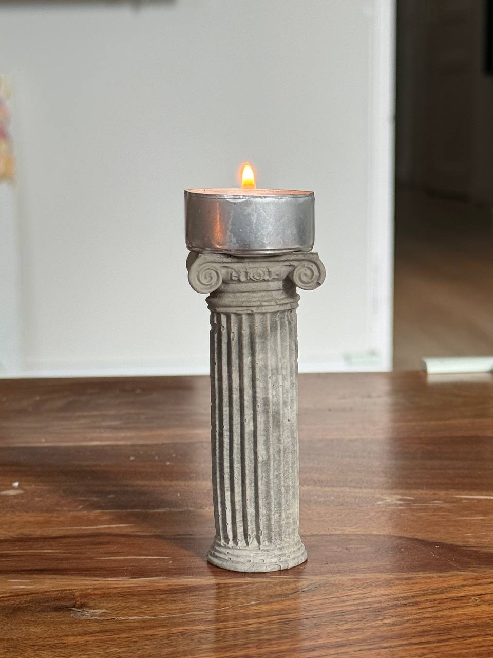 Concrete Ionic column candle holder with a lit tealight on top by Lily Glow Home Decor