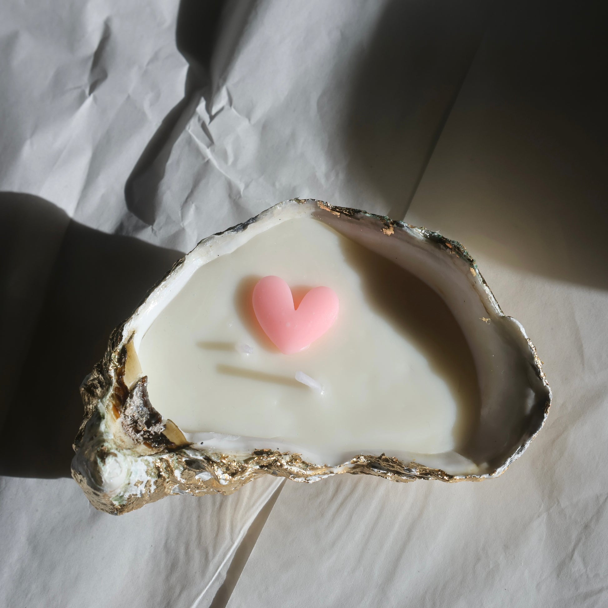 Side angle of heart-decorated seashell candle with gold foil edge by Lily Glow Home Decor