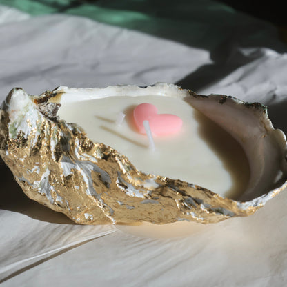 Oyster shell candle with a pink heart detail on crumpled white background by Lily Glow Home Decor