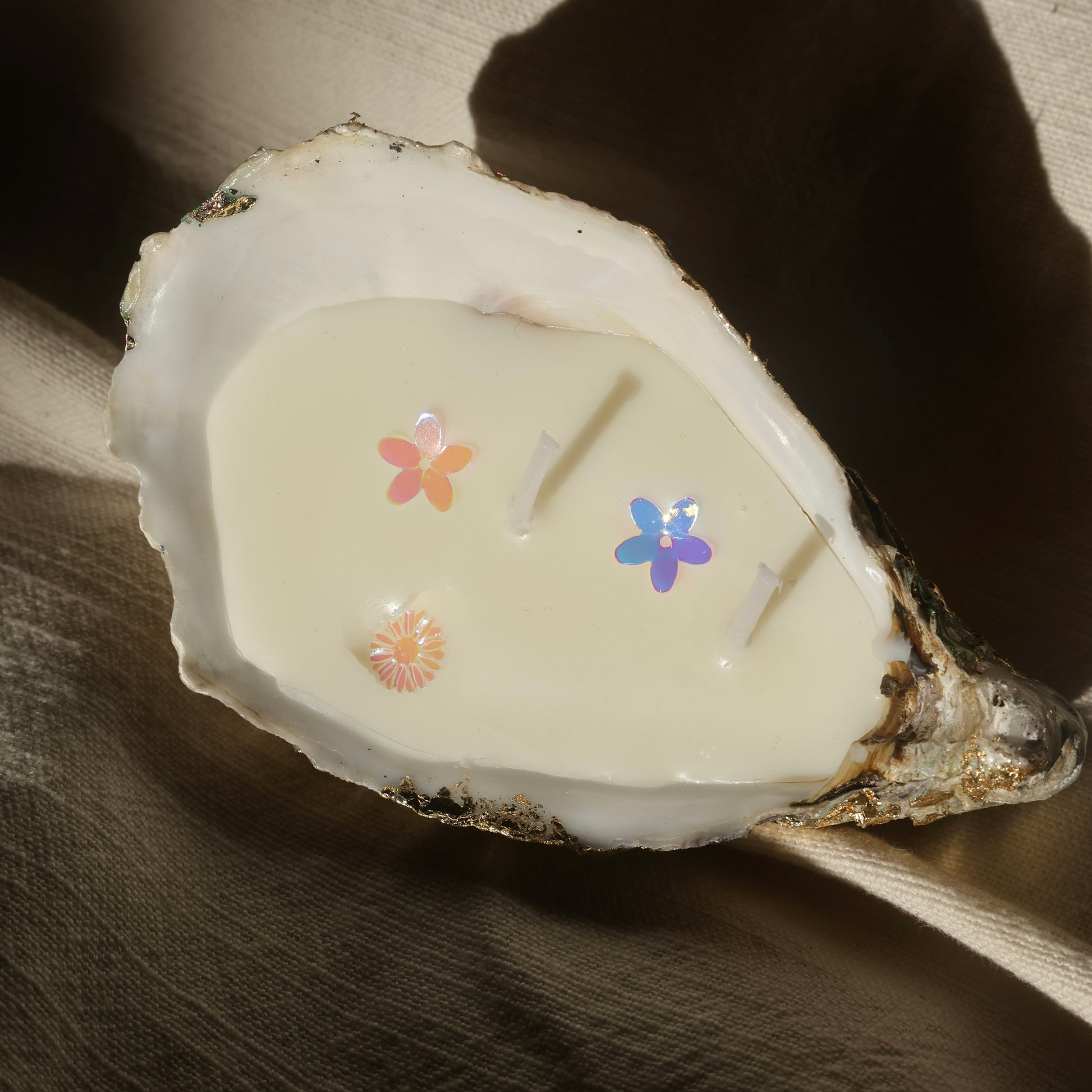 Seashell candle with glitter flowers and soft shadows by Lily Glow Home Decor