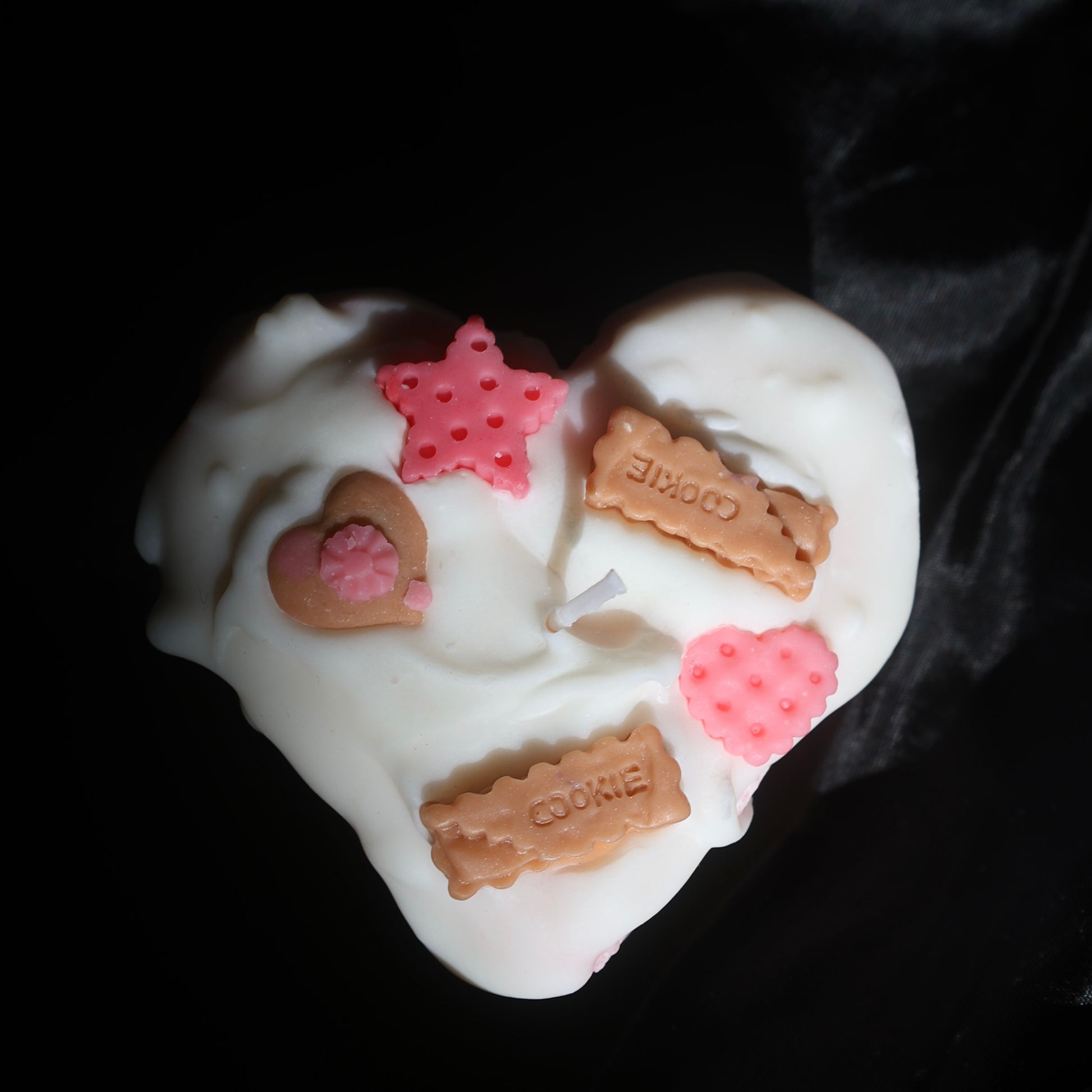 Heart-shaped candle with white frosting and cookie decorations by Lily Glow Home Decor