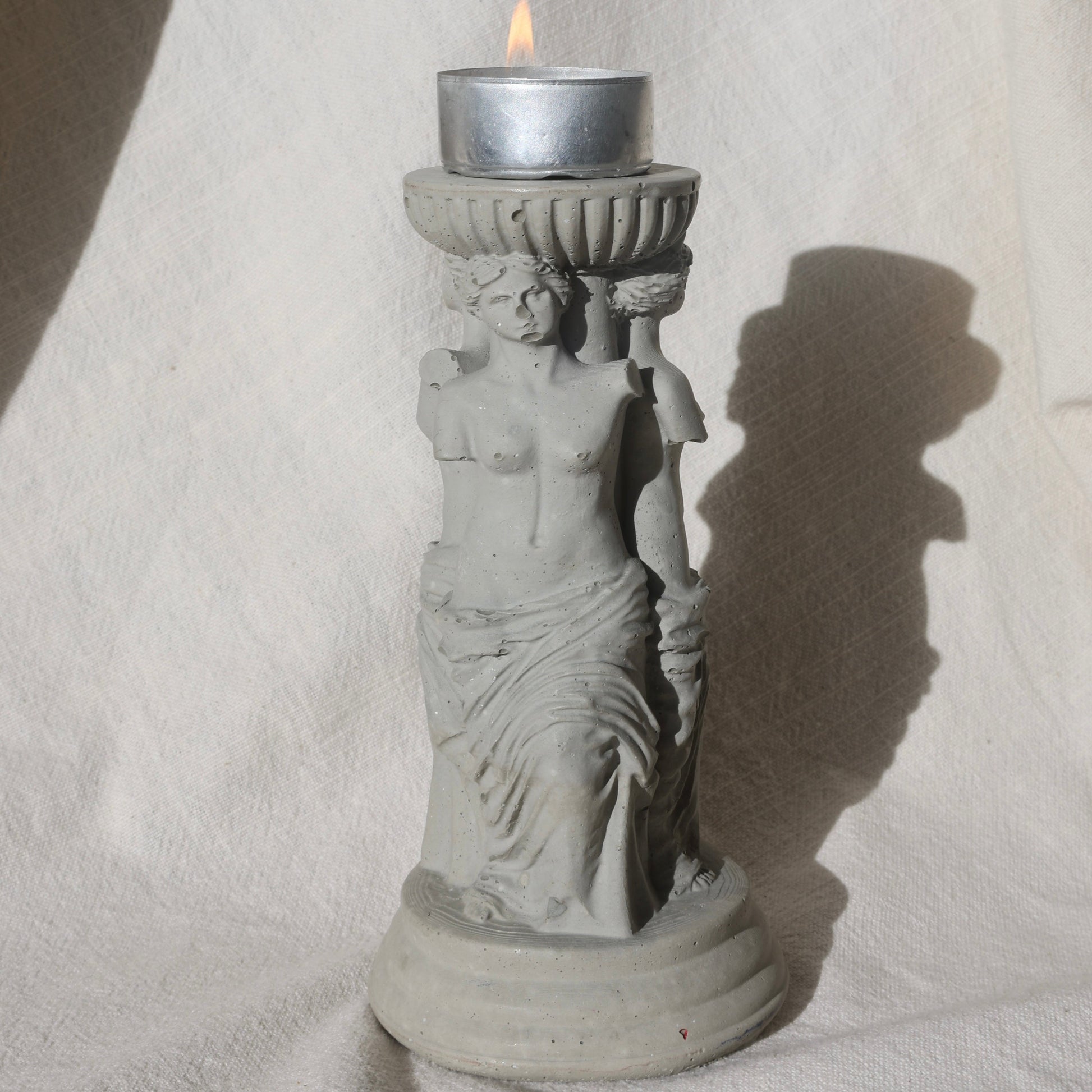 Concrete candle holder with three Venus by Lily Glow Home Decor figures and a tealight candle