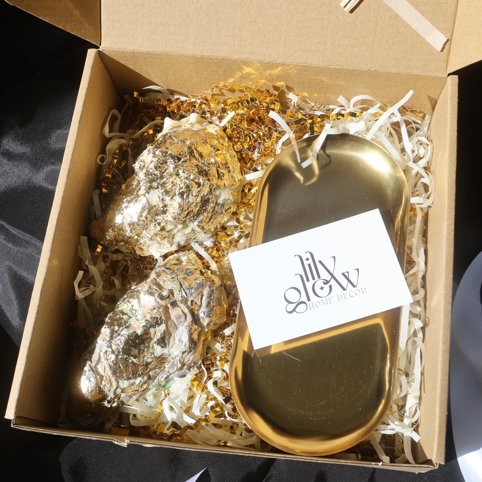 Gift box with two gold-covered seashell candles and a golden candleholder from Lily Glow Home Decor