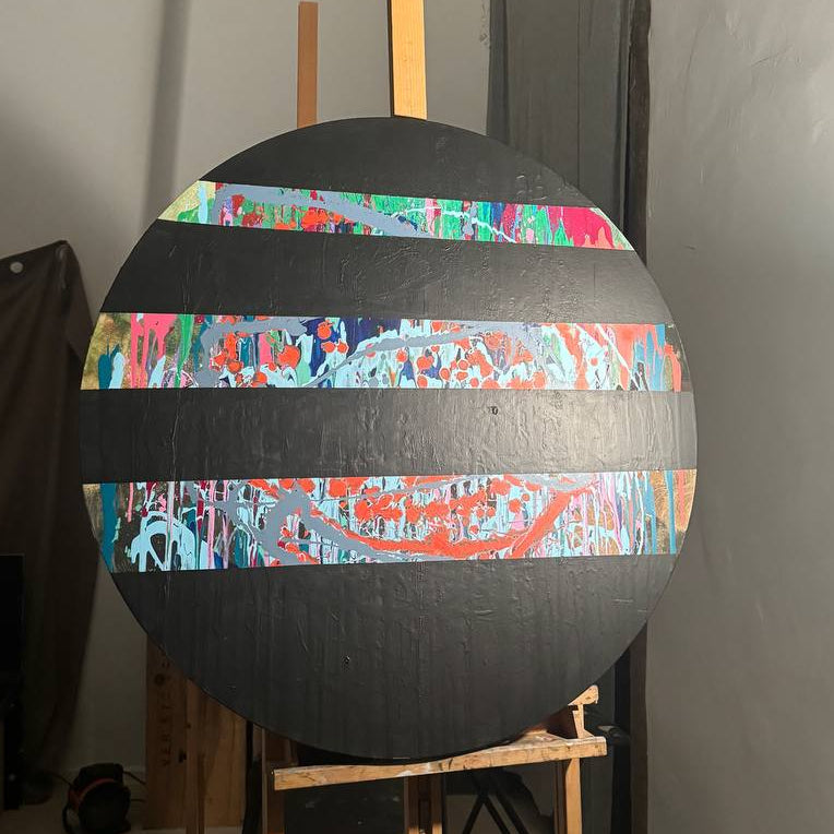 Round abstract painting with colorful splashes and black stripes by Lily Glow Home Decor